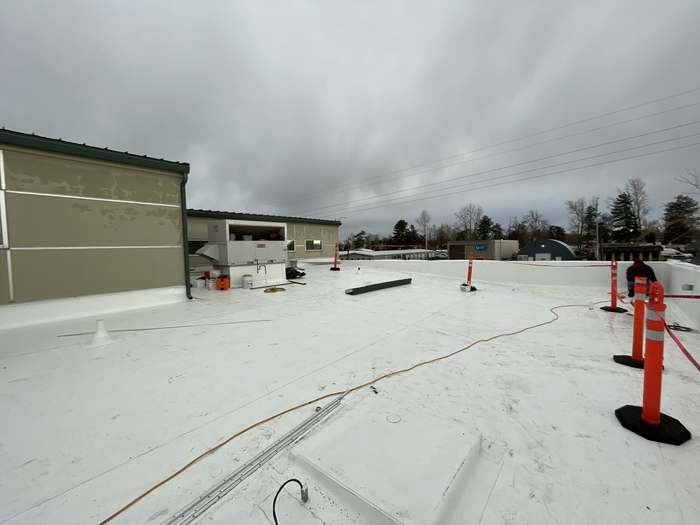 New commercial roof construction with crew on the deck